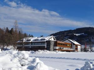 un edificio nella neve con la neve ammucchiata di Seminar- & Sporthotel Freunde der Natur a Spital am Pyhrn