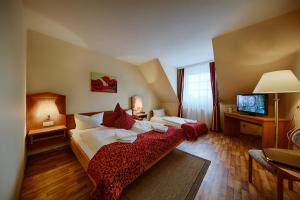 a hotel room with two beds and a television at Hotel Auerhahn in Masserberg