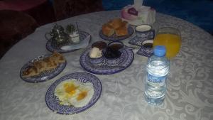 - une table avec des assiettes de nourriture et une bouteille d'eau dans l'établissement Hôtel Tijani, à Fès