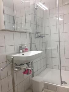 a white bathroom with a shower and a sink at Reikistudio Venedig in Quedlinburg