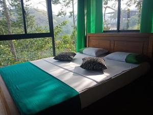 a bed in a room with a large window at Ella Mount Relax Cottage in Ella