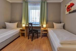 a room with two beds and a desk and a chair at Hotel Gasthof Krone in Zusmarshausen