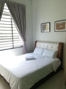 a bedroom with a white bed with a window at Desaru Arcadia Semi D Rooms Rental Available in Desaru