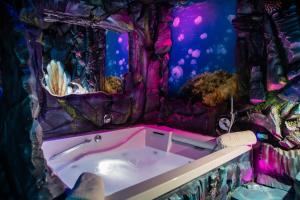 una vasca da bagno in una stanza con acquario di MagicSuite Guest House Roma Portuense a Roma