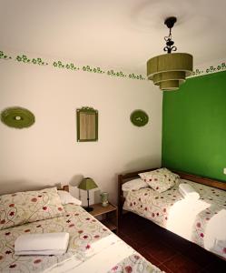 2 camas en una habitación con verde y blanco en Casa Rural La Alegría de la Alcarria III en Torremocha del Campo