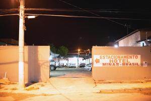 a sign in a parking lot at night at Hotel Minas Brasil in Salinas