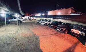 a group of cars parked in a parking lot at night at Hotel Minas Brasil in Salinas