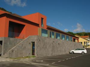 un'auto parcheggiata in un parcheggio di fronte a un edificio di Azores Youth Hostels - São Jorge a Calheta