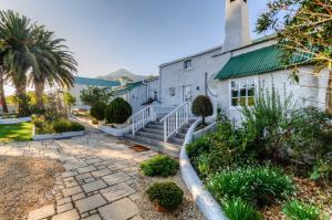 una casa con una pasarela de piedra delante de ella en The Post House Hotel - no children under the age of 16yrs en Greyton