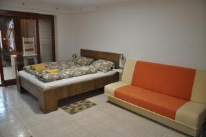 ein Bett und ein Sofa in einem Zimmer in der Unterkunft Penzion Kimex in Znojmo