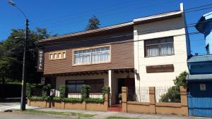a brown and white building on a street at Hostal Mackay Temuco in Temuco