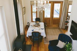 The Victorian Goose في كيب تاون: غرفة طعام مع طاولة بيضاء وثريا