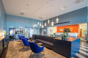 a lobby with a couch and blue chairs at Stay2Munich Hotel & Serviced Apartments in Brunnthal