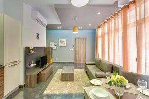 uma sala de estar com um sofá e uma televisão em Chalet Apartments em Sliema