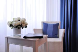 a table with a blue pillow and a vase of flowers at Hotel Miramar in Hamburg