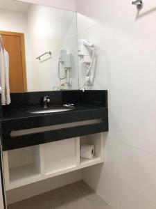 a bathroom with a sink and a mirror at Hotel Matrix in Apucarana