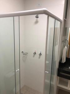 um chuveiro numa casa de banho com uma porta de vidro em Hotel Matrix em Apucarana