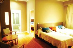 1 dormitorio con 2 camas, mesa y silla en Grand Hotel Santa Teresita en Mar del Plata