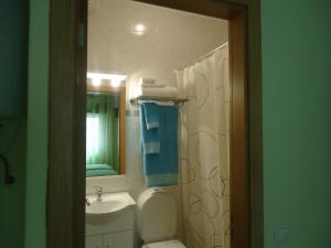 a bathroom with a sink and a toilet and a mirror at Quarto in Alvor