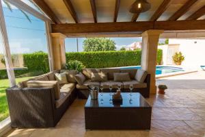 a patio with a couch and a coffee table at Villa ALZINA in Cala Millor