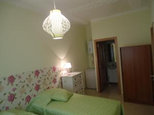 a bedroom with a green bed and a chandelier at Quarto in Alvor