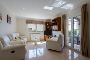 a living room with two white couches and a tv at Villa ALZINA in Cala Millor