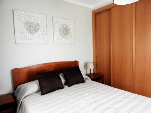 una camera da letto con un letto con due cuscini sopra di Casa Julieta ad Alvor
