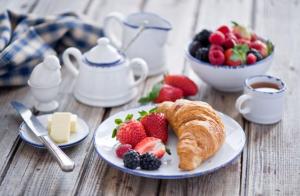 a plate with a croissant and fruit on a table at B&B Capo al Piano in Marciana Marina