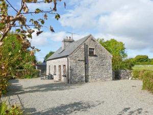 an old stone building in the middle of a field at Clooncorraun Cottage in Ballinrobe