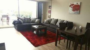 a living room with a couch and a table at Beach Pacific Apartments in Waihi Beach