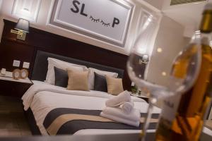 a bedroom with a bed and a wine glass at Sokratis Hotel in Nea Moudania