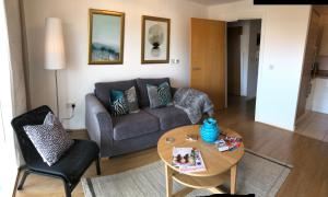 een woonkamer met een bank en een tafel bij Hansen House Cardiff Apartment with Parking in Cardiff