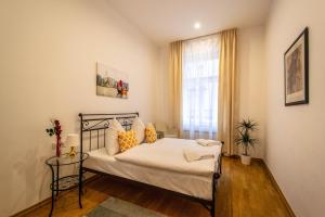 プラハにあるVojtesska Apartment By Ruterraのベッドルーム1室(オレンジ色の枕と窓付)