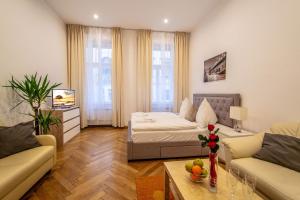 ein Wohnzimmer mit einem Sofa und einem Bett in der Unterkunft Vojtesska Apartment By Ruterra in Prag