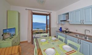 a kitchen with a table and a view of a balcony at Residence Besass, GTSGroup in Tignale