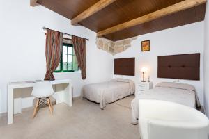 a bedroom with two beds and a desk at Casa Las Zocas in San Miguel de Abona