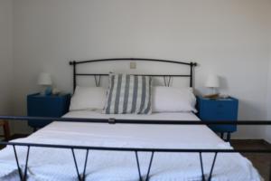 a bed in a bedroom with blue cabinets and a bedskirts at Avgoustis' stone house in Otziás