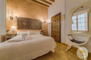 um quarto com uma cama branca e um espelho em Hotel Argantonio em Cádiz