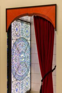 a door with a stained glass window next to a red curtain at Aparthotel Adagio Köln City in Cologne