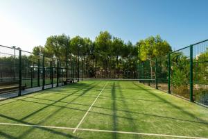 a grassy area with a fence and a tennis court at Iberostar Albufera Playa in Playa de Muro