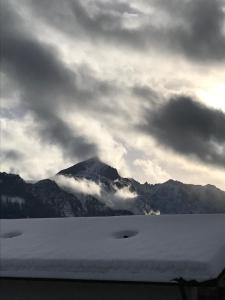 een met sneeuw bedekte berg voor een waterlichaam bij Ferienwohnung zum Servus in Garmisch-Partenkirchen