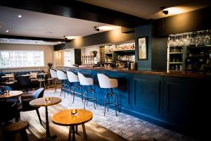 a bar with chairs and tables in a restaurant at The Fox in Winchester