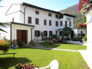 a large white house with a yard at Agriturismo Alle Ruote in Meduno