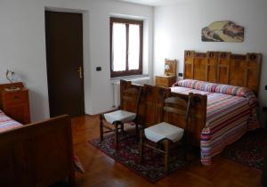 a room with a bed and two chairs and a window at Agriturismo Alle Ruote in Meduno