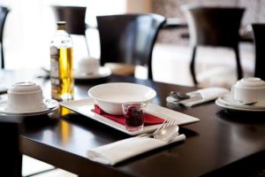 a table with a plate with a bowl and a glass at Tara Lodge in Belfast