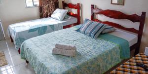 two beds in a room with two at Pousada Panceiro in Cabo Frio