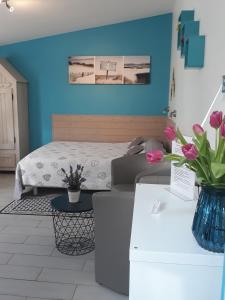 ein Schlafzimmer mit einem Bett und einer blauen Wand in der Unterkunft Chevrefeuille et Eglantine in LʼÎle-dʼOlonne