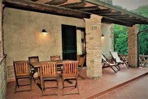 Une table et des chaises en bois sont disponibles sur la terrasse. dans l'établissement Casa delle Palme, à Monsagrati