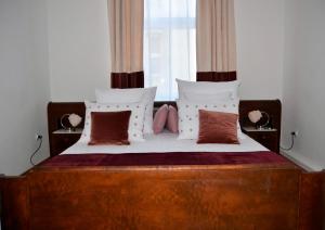 a bedroom with a bed with a wooden headboard and pillows at Castle View Boutique Apartment in Krakow