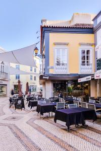 un patio con mesas y sillas y un edificio en A Casa D'Amelie, en Faro
